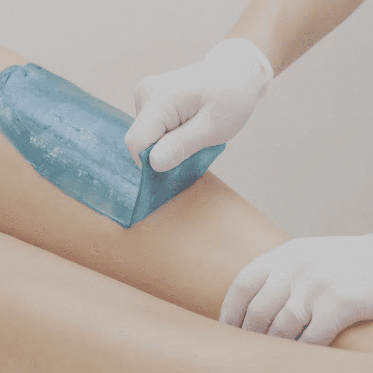 A person is waxing their legs with a blue block.